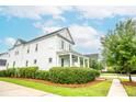 Angle view of a white two-story home with a inviting front porch and lush landscaping, showcasing its classic design at 3707 Gambrill Ln, Mount Pleasant, SC 29466