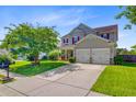 Beautifully landscaped two-story home with a manicured lawn, front porch, and an attached two-car garage at 407 Glenmore Dr, Moncks Corner, SC 29461