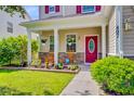 Cozy front porch with rocking chairs and blooming flower beds, creating an inviting entrance to the home at 407 Glenmore Dr, Moncks Corner, SC 29461