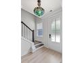 Bright entryway with a decorative light fixture, wooden floors, and a staircase at 5133 Park Creek Ave, North Charleston, SC 29418