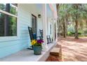 Cozy front porch with black rocking chairs and colorful flower pots, perfect for relaxing at 5233 Maybank Hwy, Wadmalaw Island, SC 29487