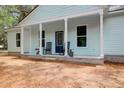 Inviting front porch with rocking chairs, decorative plants, and a stylish front door at 5233 Maybank Hwy, Wadmalaw Island, SC 29487
