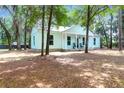 Charming exterior of the home, surrounded by trees, and a cozy front porch at 5233 Maybank Hwy, Wadmalaw Island, SC 29487
