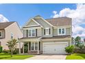 Two-story home showcasing a well-manicured lawn, gray siding, and a two-car garage on a sunny day at 535 Crossland Dr, Moncks Corner, SC 29461