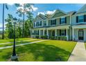 Beautiful townhomes with manicured lawns, sidewalks, and black trim evoke feelings of home at 618 Ravensridge Ln, Moncks Corner, SC 29461