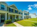 Charming row of townhomes with well-manicured lawns, and sidewalks creates an inviting curb appeal at 618 Ravensridge Ln, Moncks Corner, SC 29461