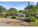 Quaint home boasts a charming white picket fence, lush landscaping, and inviting curb appeal at 708 Pitt St, Mount Pleasant, SC 29464