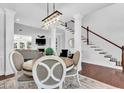 Open-concept dining area with hardwood floors, staircase, and views into the living room at 1003 Jervey Point Rd, Wando, SC 29492