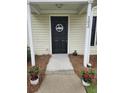 Close-up of the front door with a 'Welcome' decoration, flanked by potted flowers at 103 Dupont Way, Summerville, SC 29485