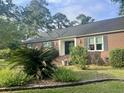 Well-maintained brick home featuring a landscaped front yard with mature plants and classic architectural details at 104 Silverhill Rd, Walterboro, SC 29488