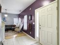 Inviting entryway with tiled floor leading into a living area with a gray couch and modern rocking chair at 108 Spanish Oaks Ln, Ladson, SC 29456