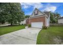 View of a brick and siding home with manicured yard and a long concrete driveway leading to a 2-car garage at 116 Holbrook Ln, Goose Creek, SC 29445