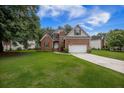 Charming two-story brick home featuring an attached two car garage and a well-manicured lawn at 116 Holbrook Ln, Goose Creek, SC 29445