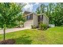A side view of a two story townhome with lush green grass in the front yard and blue sky at 124 Bright Meadow Rd, Summerville, SC 29483