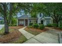 Inviting townhome exterior featuring a paved walkway, mature trees, and well-maintained landscaping at 1304 Elm Hall Cir, Summerville, SC 29483
