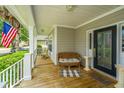 Inviting front porch with decorative columns, wicker furniture, and a welcoming American flag at 1409 Bloomingdale Ln, Mount Pleasant, SC 29466
