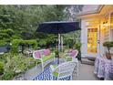 Back patio features outdoor seating with an umbrella, beautiful plants, and manicured shrubs at 148 Longdale Dr, Summerville, SC 29483
