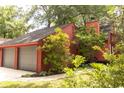 Charming exterior of red home featuring an attached two-car garage and mature trees at 152 Mansfield Blvd, Charleston, SC 29418