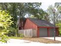 Exterior of red home with attached two-car garage, side yard, and mature trees at 152 Mansfield Blvd, Charleston, SC 29418