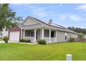 Home exterior with a welcoming front porch, solar panels, and well-maintained landscaping at 173 Southport Dr, Summerville, SC 29483