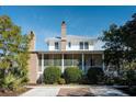 Two-story home with brick chimney, screened porch, and lush landscaping at 222 Haddrell St, Mount Pleasant, SC 29464
