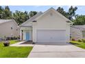 Well-maintained single-Gathering home featuring a bright blue door, two-car garage, and landscaped front at 252 Island Green Rd, Goose Creek, SC 29445