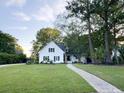 Beautiful white home with a well-maintained lawn, mature trees, and a walkway leading to the entrance at 27 Fitzroy Dr, Charleston, SC 29414