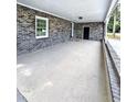Covered patio with gray brick exterior and gray flooring, offers a view of the yard at 4649 N U.S. Highway 52, Saint Stephen, SC 29479