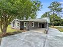 View of home with brick exterior, white trim, and covered parking area; concrete driveway and landscaping at 4649 N U.S. Highway 52, Saint Stephen, SC 29479