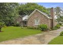 Beautiful brick home with lush green lawn and mature trees along the driveway at 4735 W Park Pl, North Charleston, SC 29405