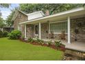 Inviting front porch with brick columns and seating overlooking the landscaped lawn at 4735 W Park Pl, North Charleston, SC 29405