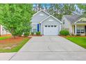 Charming home featuring a driveway and attached garage, complemented by a well-maintained lawn and colorful landscaping at 4831 Carnoustie Ct, Summerville, SC 29485