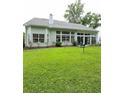 Back exterior showcasing a sunroom surrounded by a well-kept yard and mature trees at 605 Pointe Of Oaks Rd, Summerville, SC 29485