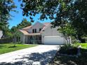 Traditional two-story home with a well-manicured lawn, front porch, and spacious driveway at 6212 Fieldstone Cir, Charleston, SC 29414