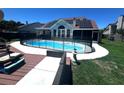 Backyard pool with a safety fence, solar panels, and deck, offering a relaxing outdoor experience at 6212 Fieldstone Cir, Charleston, SC 29414