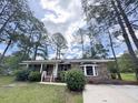 Beautiful brick home surrounded by lush green landscaping and towering mature trees at 710 Gadsden Loop, Walterboro, SC 29488