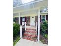 Welcoming front porch with brick steps and elegant white railings leading to front door at 710 Gadsden Loop, Walterboro, SC 29488