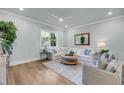 Inviting living room with large windows, hardwood floors, and comfortable seating arrangement at 7432 Indigo Palms Way, Johns Island, SC 29455