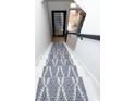 Looking down a staircase with white risers, patterned blue and white runner, and black handrail at 760 Natchez Circle Cir, Mount Pleasant, SC 29464