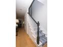 Hallway featuring hardwood floors, staircase with patterned runner and black handrail, and bright white walls at 760 Natchez Circle Cir, Mount Pleasant, SC 29464