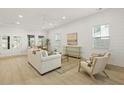 Open-concept living room features shiplap wall, light hardwood, and a white sofa at 868 Tripe St, Charleston, SC 29407