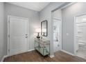Bright entryway features wood flooring, a console table with lamps, and doorways to a bedroom and bathroom at 104 Orchard Blossom Ln, Summerville, SC 29485