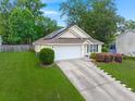 This home features an attached garage, complemented by a neat lawn and flourishing landscaping at 1042 Steelechase Ln, Hanahan, SC 29410