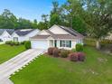 Inviting home with an attached garage, lush lawn, mature trees, and an appealing facade at 1042 Steelechase Ln, Hanahan, SC 29410