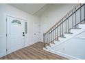 Bright foyer with wood floors, white wainscoting, staircase, and a decorative glass front door at 105 Glebe Rd, Summerville, SC 29485