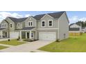 Charming two-story home with gray siding, a white garage door, and a well-manicured lawn at 105 Oast Ln, Summerville, SC 29485