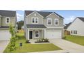 Charming two-story home with gray siding, a white garage door, and a well-manicured lawn at 105 Oast Ln, Summerville, SC 29485