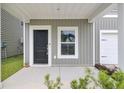 Welcoming front porch with a black door, adjacent window, and neat landscaping at 105 Oast Ln, Summerville, SC 29485
