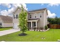 A tan two-story home with an attached garage and a green lawn at 111 Nolin Road Rd, Moncks Corner, SC 29461