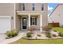 Front door entrance with a black front door, white columns, and well maintained landscaping at 111 Nolin Road Rd, Moncks Corner, SC 29461